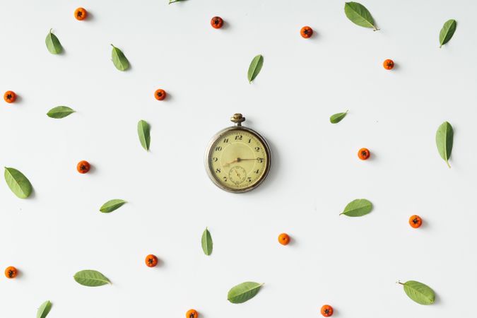 Hand clock with coffee beans with coffee fruit and leaf pattern on light background