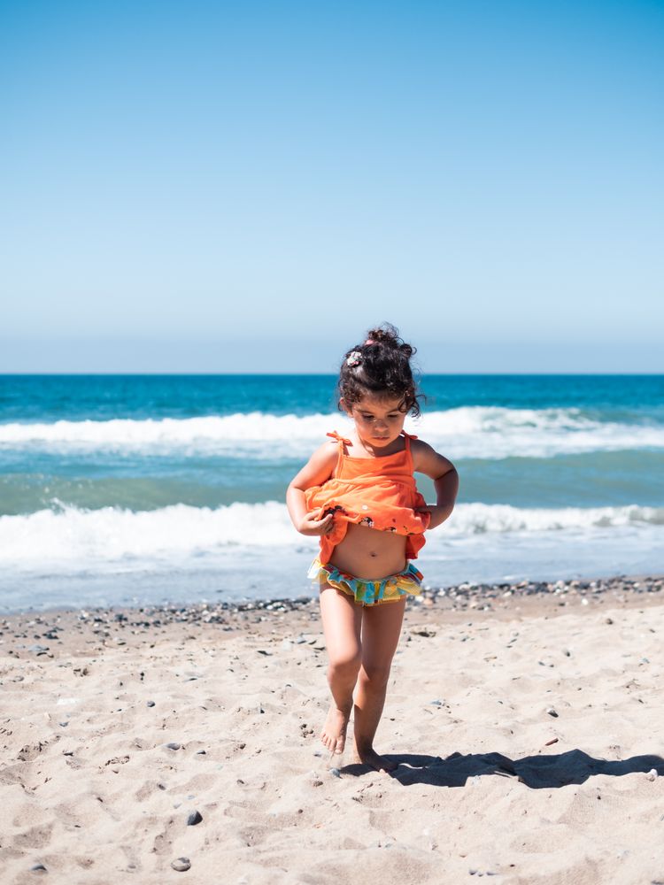 Cute twins girls playing on sandy beach