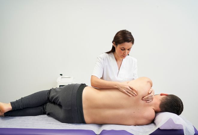 physiotherapist treating the patient's shoulder