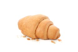 Freshly baked croissant with crumbs isolated on plain background