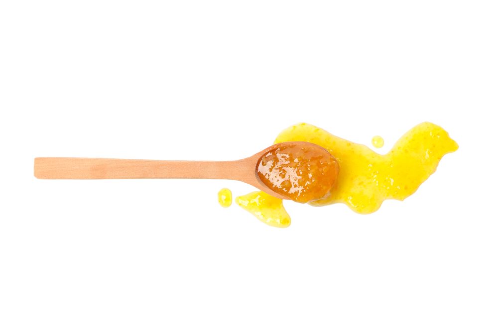 Spoon with apricot jam isolated on plain background