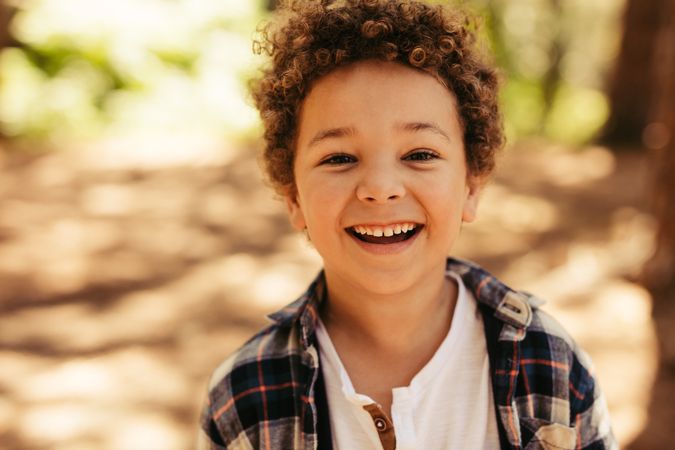 Close up portrait of cute boy smiling outdoors