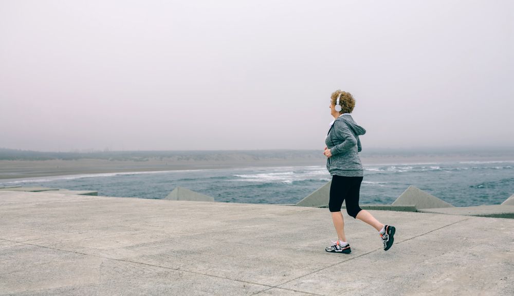 Older woman with headphones running