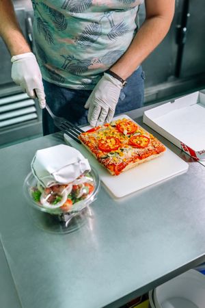 Unrecognizable cook preparing pizza to takeaway