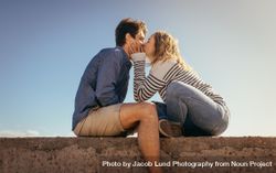 Couple on vacation in romantic mood sitting outdoors 5nlmlb