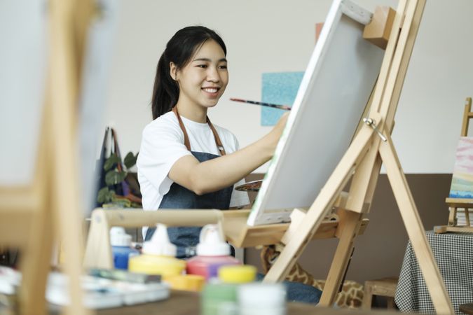 Crafting Inspiration. Female Artist Sketching and Painting in Workshop