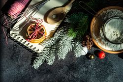 Top view of flour and ingredients for Christmas baking on dark counter