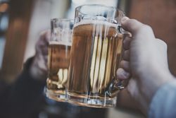 Two people cheering with beer pint