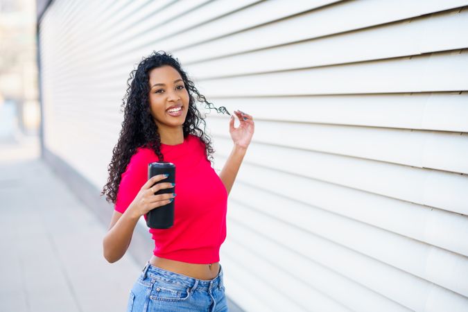 A Young Woman Enjoying a Lovely and Sunny Day While Using Her Smartphone and Smiling