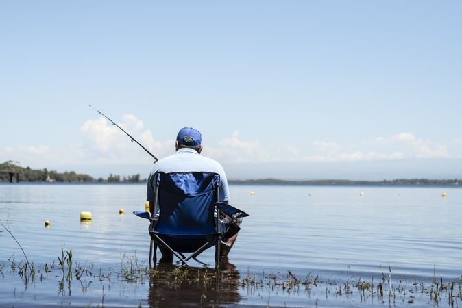 Man sitting on a chair holding fishing rod