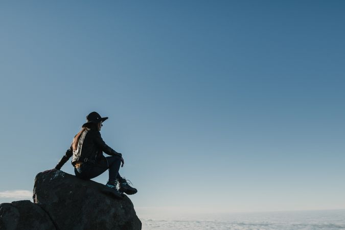 Woman sitting on rock in hillside