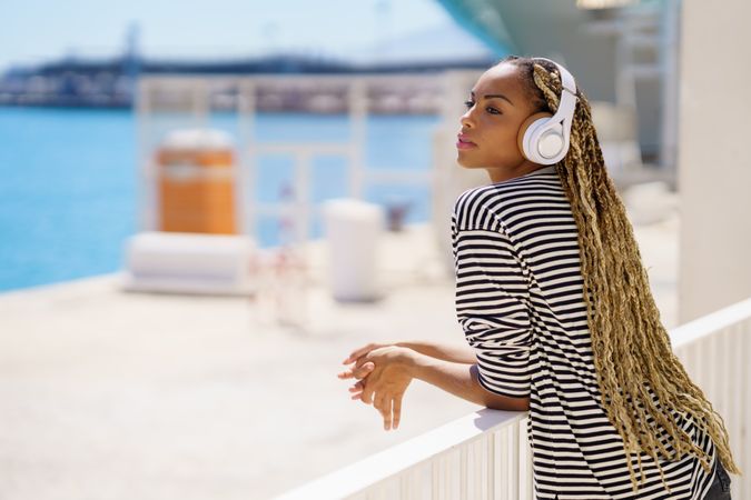 Female relaxing near water listening to music