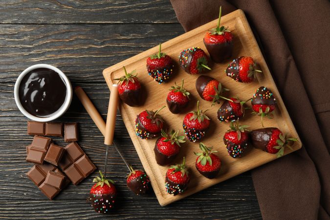 Chocolate fondue. Strawberry in chocolate on wooden background, top view