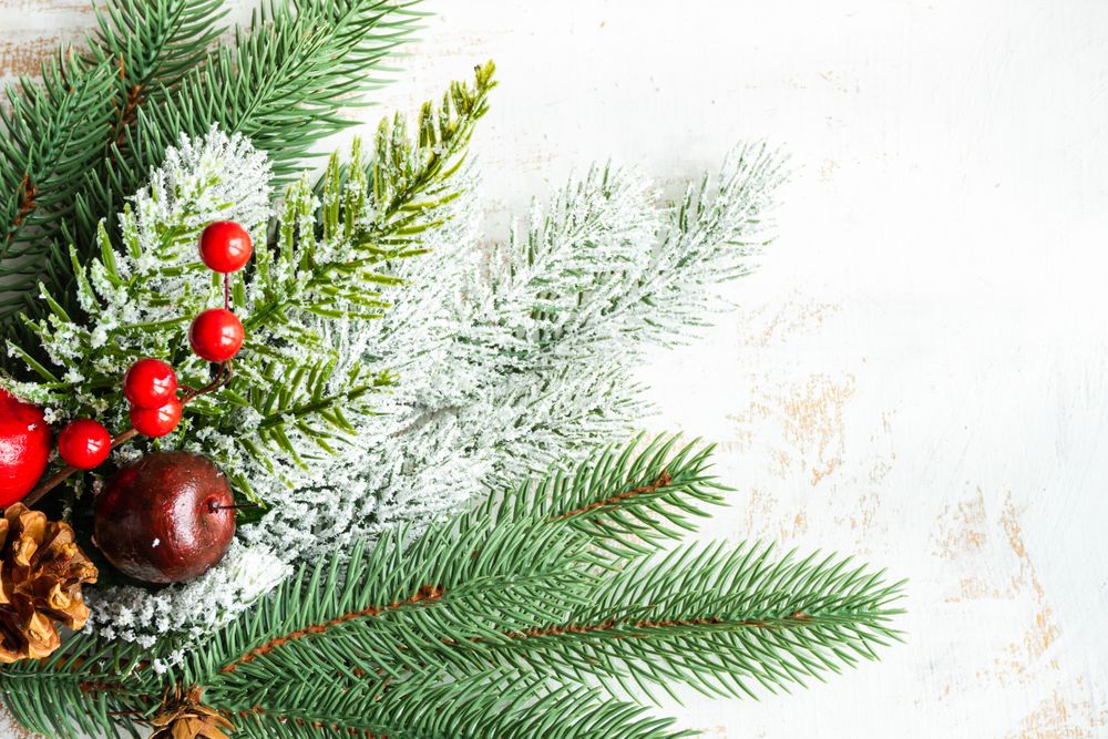 Frame of Christmas fir branches on rustic wooden table with space for text