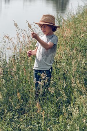 Boy in straw hat on riverside