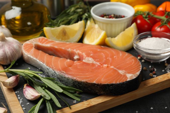 Composition with salmon meat and spices on wooden background, close up