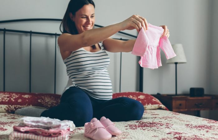 Pregnant woman looking baby girl cardigan