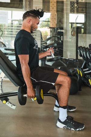 Strong man exercising with dumbbells in gym
