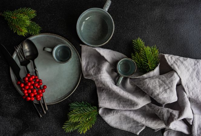 Top view of blue grey plate and mug surrounded by seasonal branch