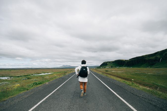 Back of man walking down desolate road