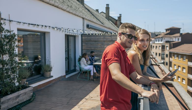 Young coworkers with mobile on the terrace