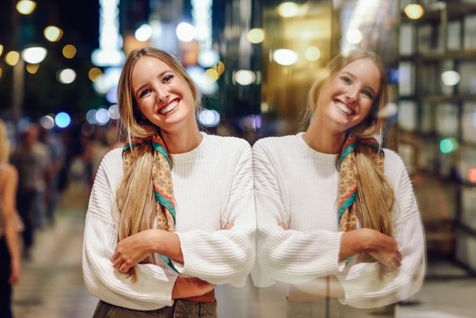 Smiling woman with window reflection at night