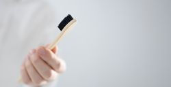 Man holding bamboo toothbrush