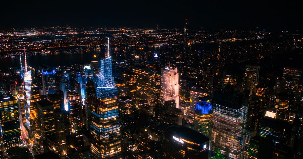 Helicopter Tour of New York City Architecture at Night. Midtown Manhattan Office Buildings and Skyscrapers Towards Madison Square Garden. Aerial Urban Landscape with Lights in the Evening