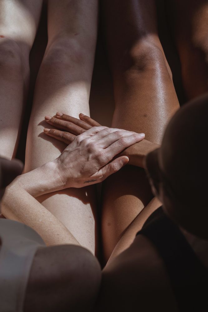 Top view of white person and Black person holding hands