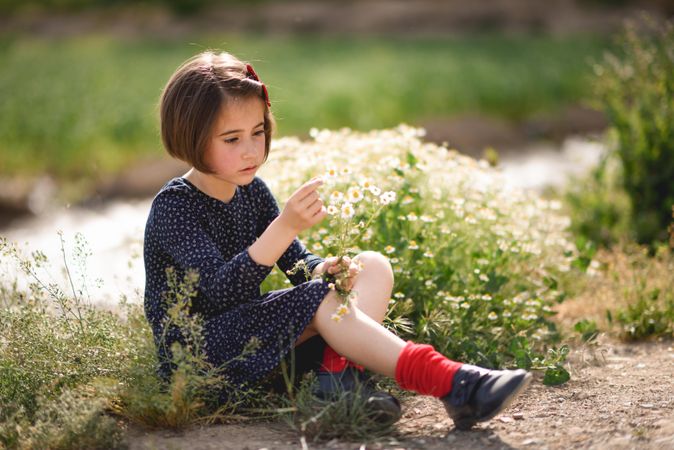 Little girl picking flowers in a beautiful park