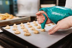 Crop baker squeezing dough on tray