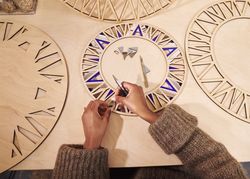 Black artist decorating a wooden frame with scapel and pliers