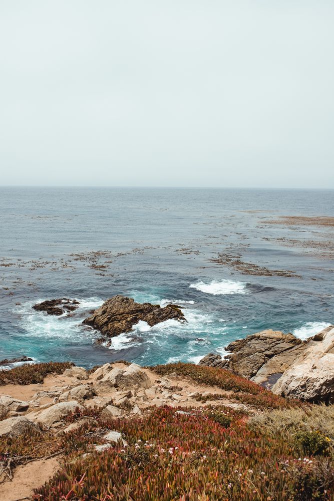 Blue waves washing rocky seashore in bright day