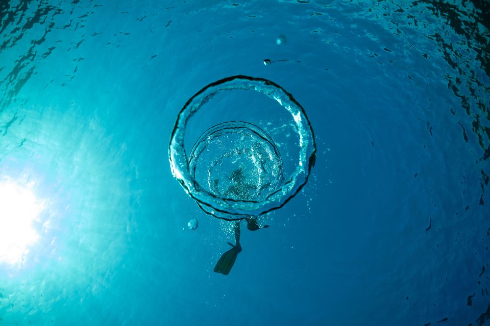 Man snorkeling in water with bubbles