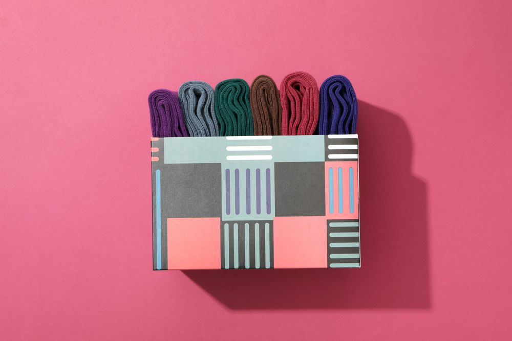 Multicolored high socks on a pink background.