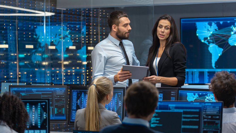 Head of the Department and Project Manager Discuss Work Process Using Data on Tablet Computer.