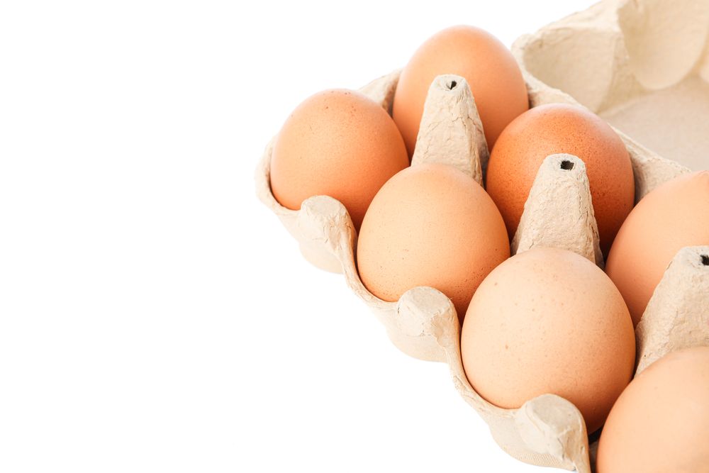 Brown chicken eggs in carton box isolated on plain background