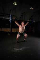 Strong man lifting barbell with weights in gym
