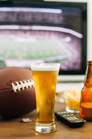 Beer and snacks prepared for watching american football on TV