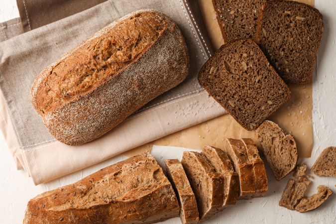 Composition with bakery products, salt and kitchen towel on neutral background, top view