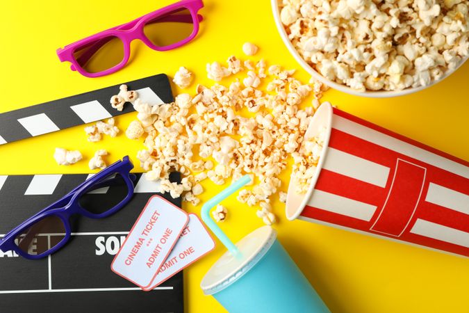 Flat lay composition with movie watching accessories on yellow background