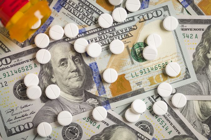 Medicine Pills Scattered on Newly Designed One Hundred Dollar Bills