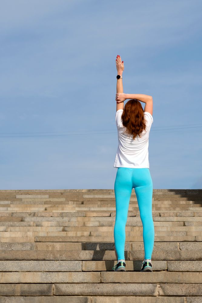 Woman doing warm up before workout on street