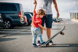 Man with kid training with skateboard