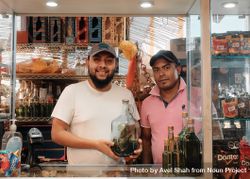 Two men in store in Oaxaca with large vat of herbal tincture 0gkBe0