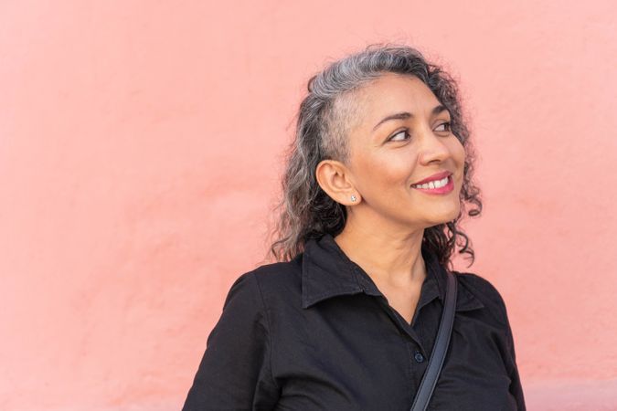 Older woman with gray hair smiling in the street.