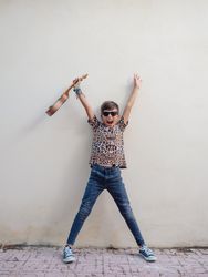 Excited kid raising hands up with ukulele