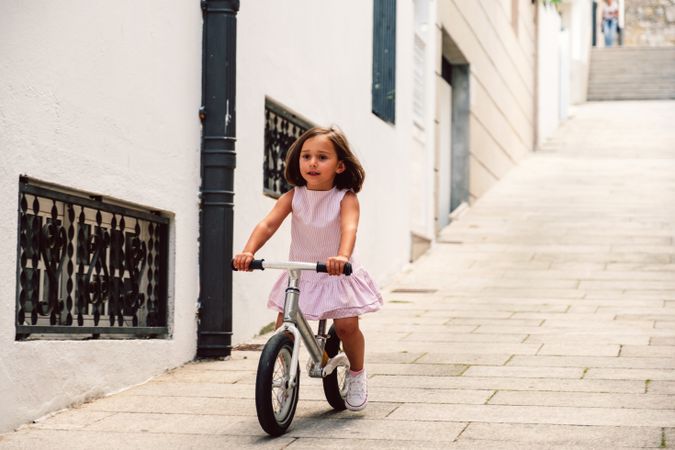 Girl riding on bicycle in narrow street