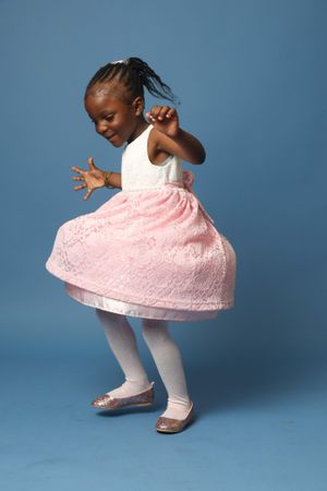 Happy Black girl in pink dress against blue background