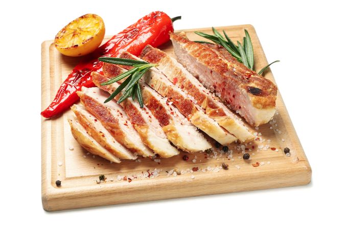 Board with chopped pork steak isolated on blank background